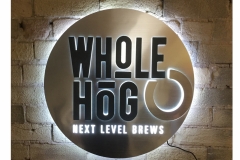 Whole Hog Metallic LED Sign  Metallic, back surface, Raised acrylic logo using edge lit and backlit LEDs, Halo lighting effect around outside of sign